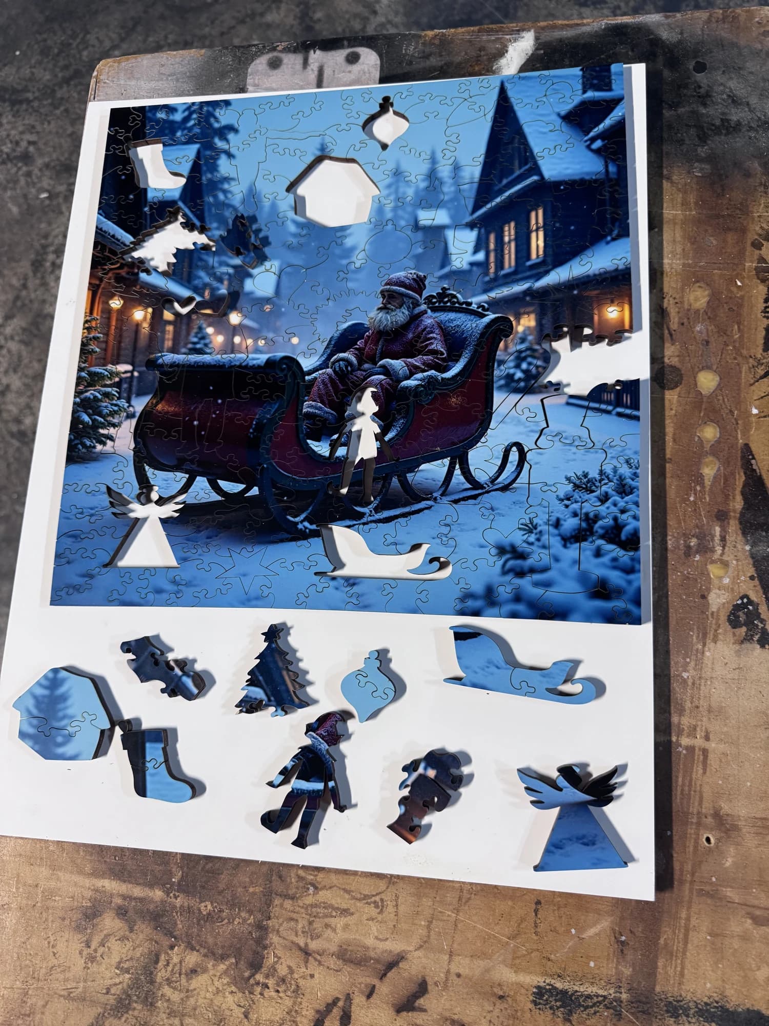 A full Christmas-themed Whittled wooden puzzle with its custom holiday whimsy pieces displayed beneath the artwork