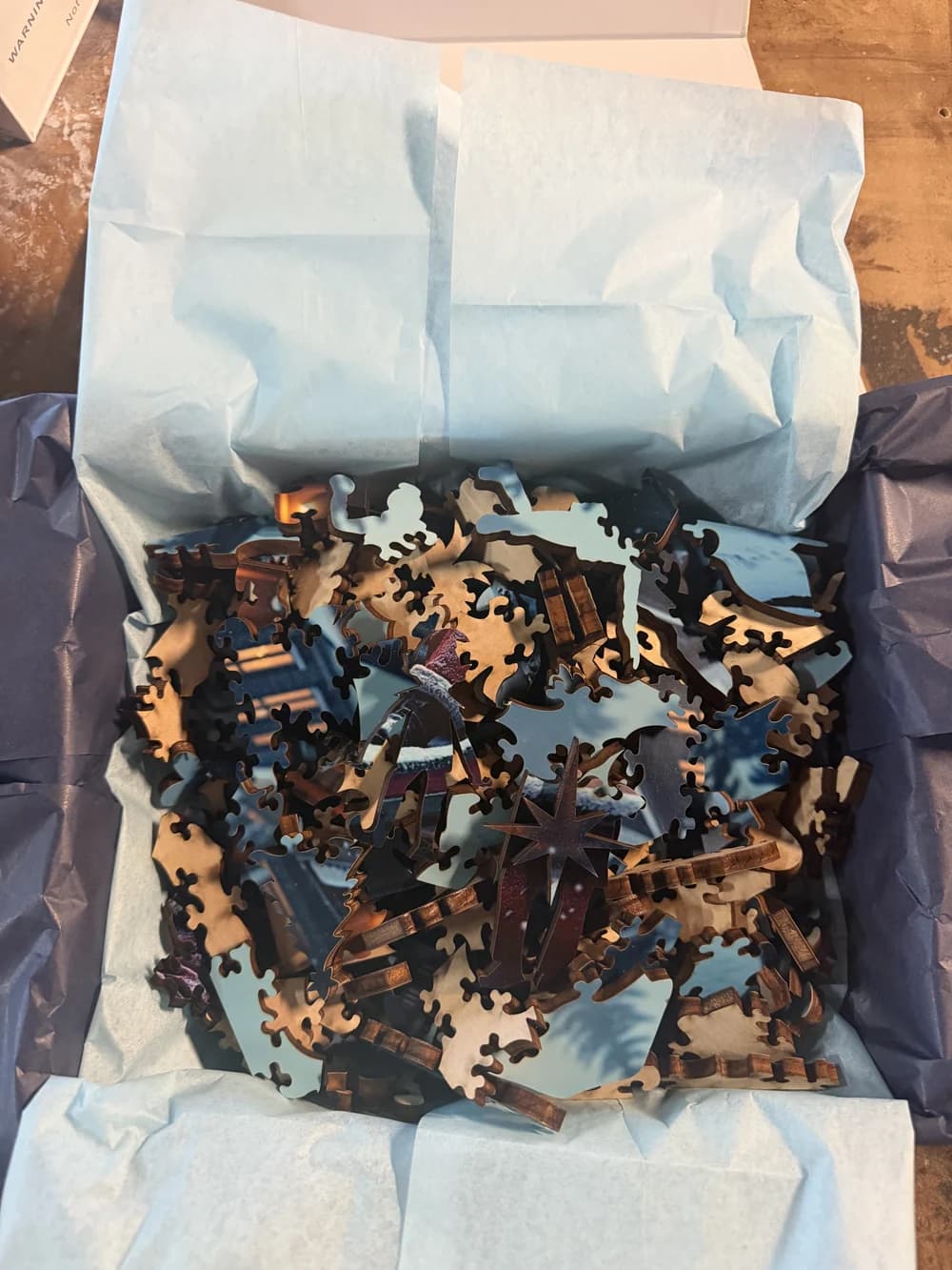 A Christmas-themed Whittled puzzle presented in its tissue-lined gift box