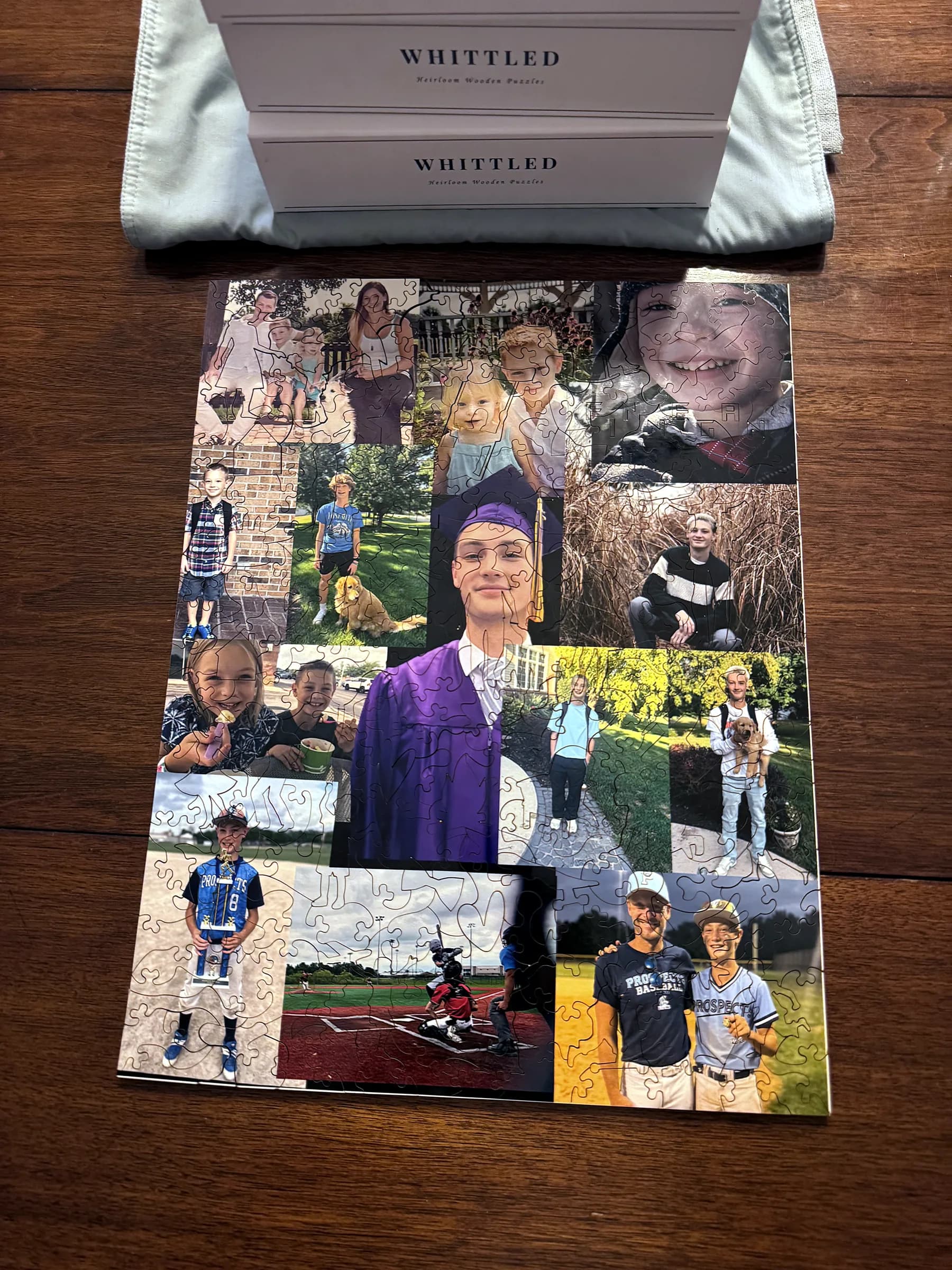 A finished graduation collage puzzle in hardwood beside two Whittled boxes and a dust pouch