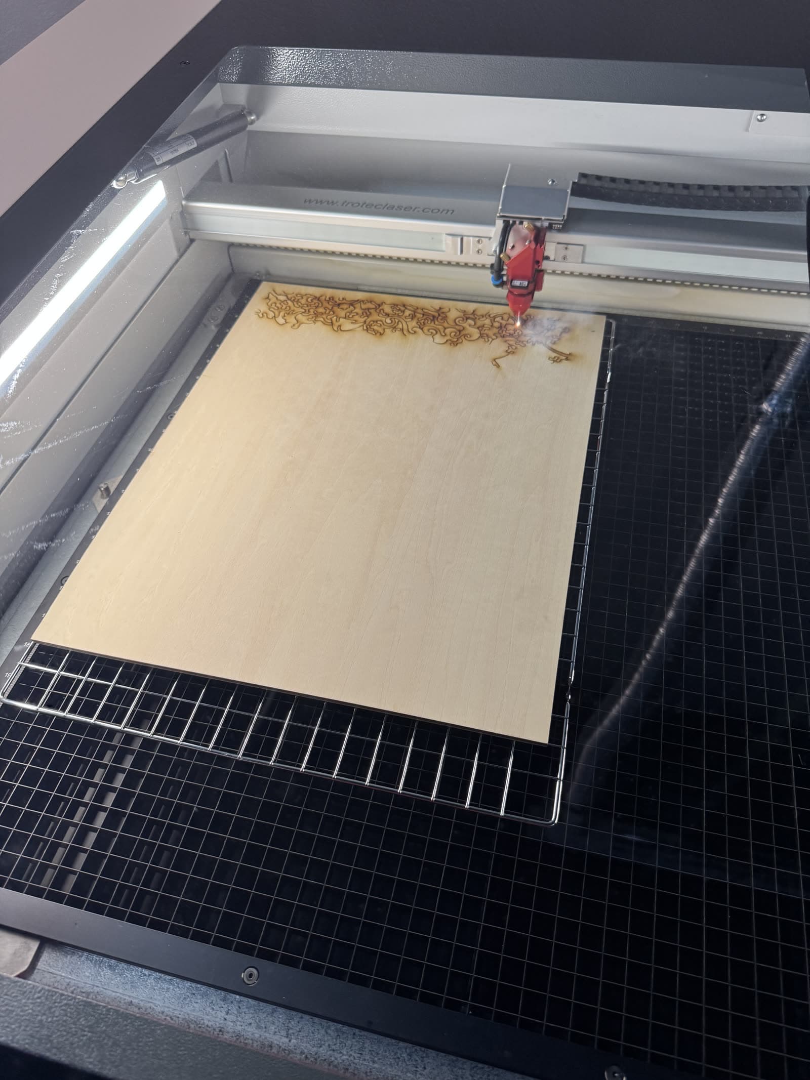 Laser cutting an intricate jigsaw pattern into a hardwood Whittled puzzle blank